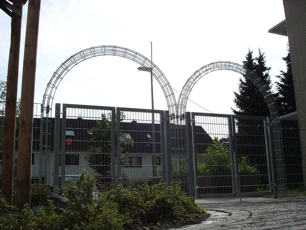 Ein Zaun mit ein paar Bäumen davor