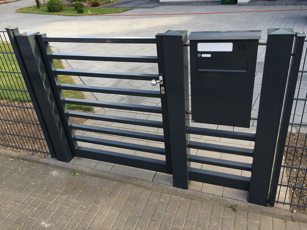 Ein schwarzes Tor mit einem daran befestigten Briefkasten
