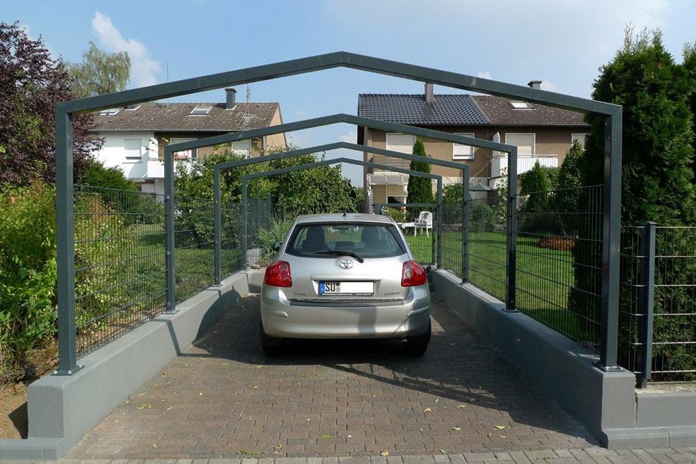 Ein silbernes Auto ist unter einer Metallkonstruktion geparkt