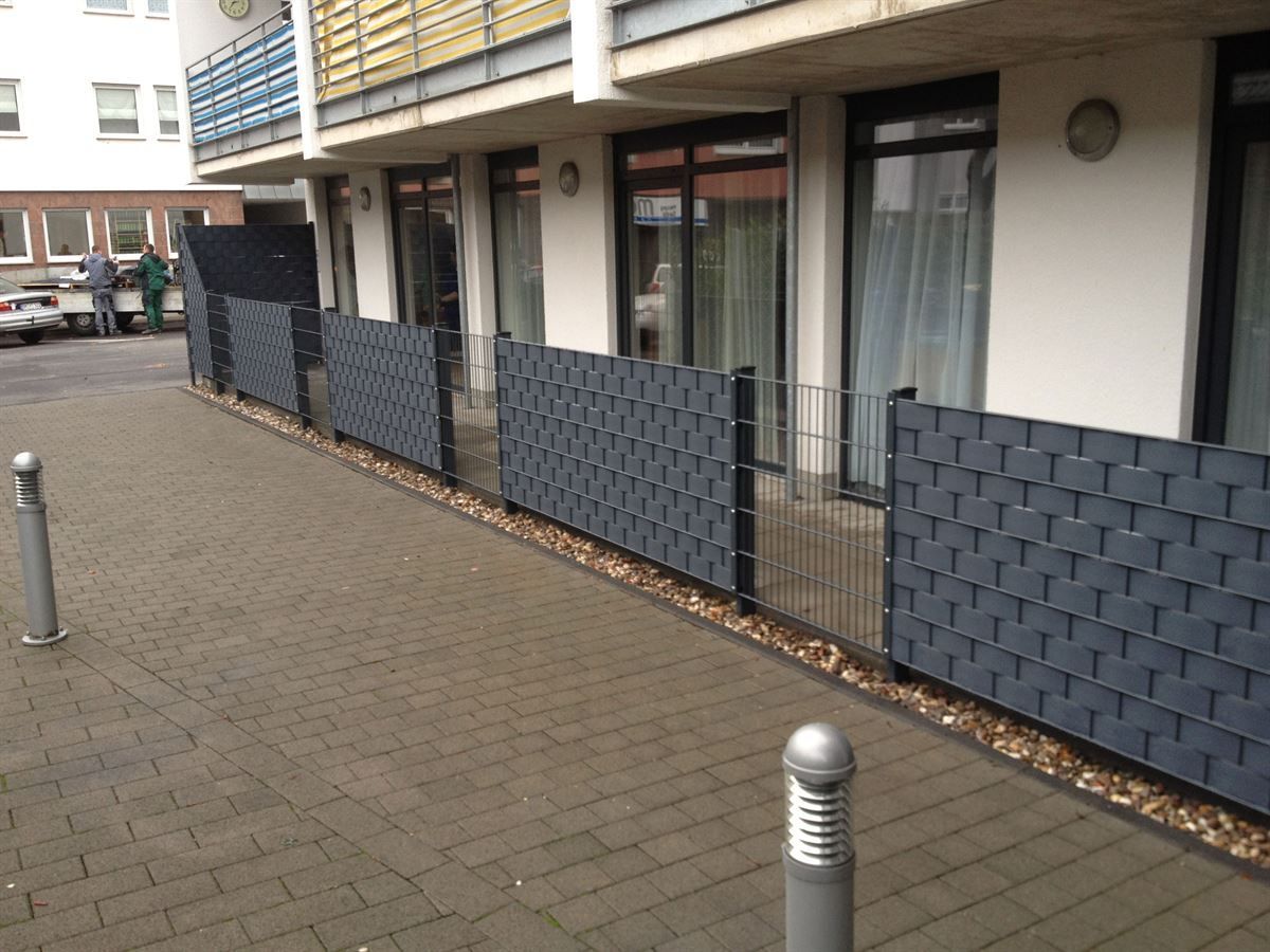 Ein Ziegelweg mit einem Zaun an der Seite