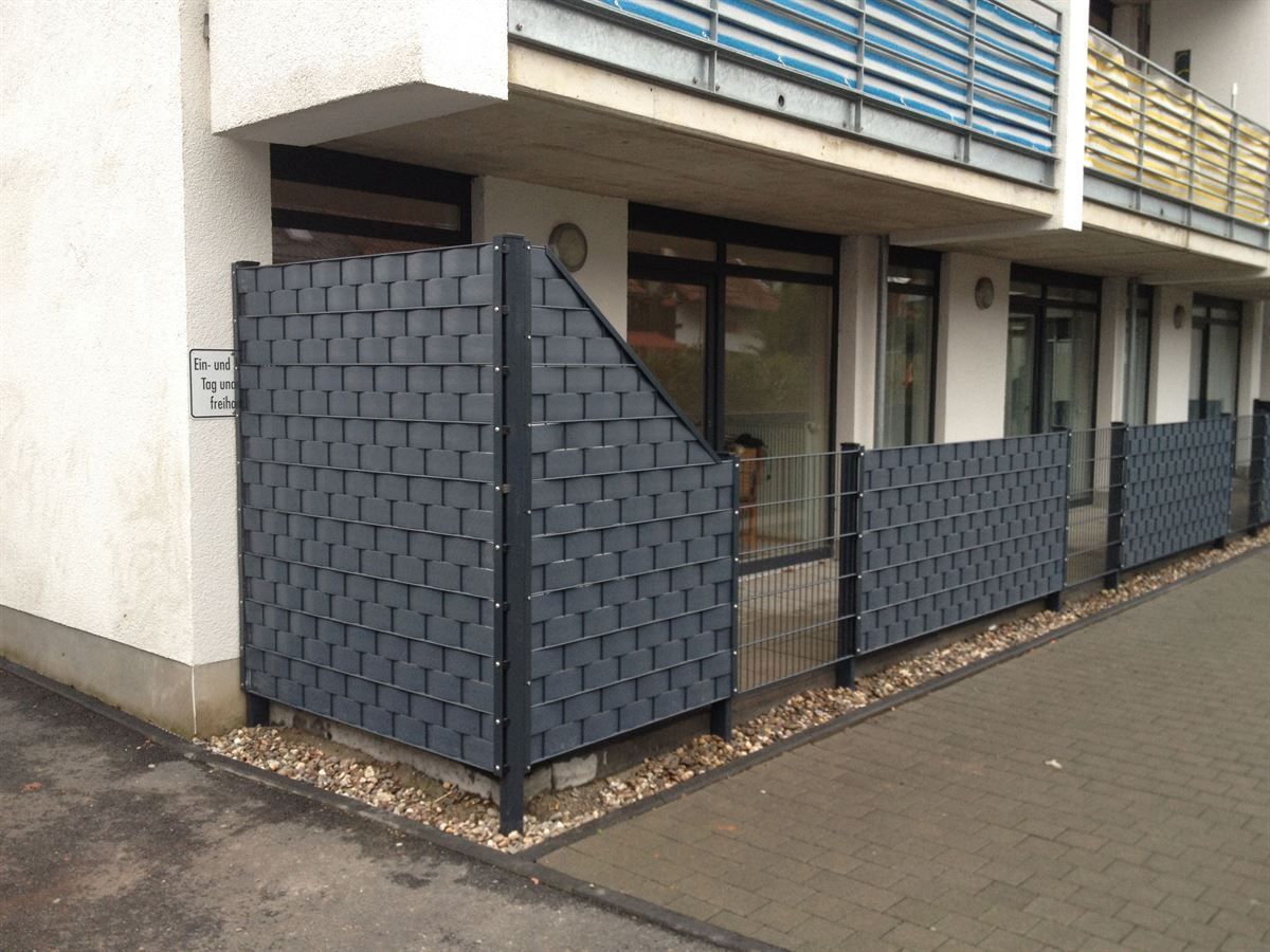 Ein Gebäude mit einem Zaun davor und einem Schild mit der Aufschrift „Parken verboten“