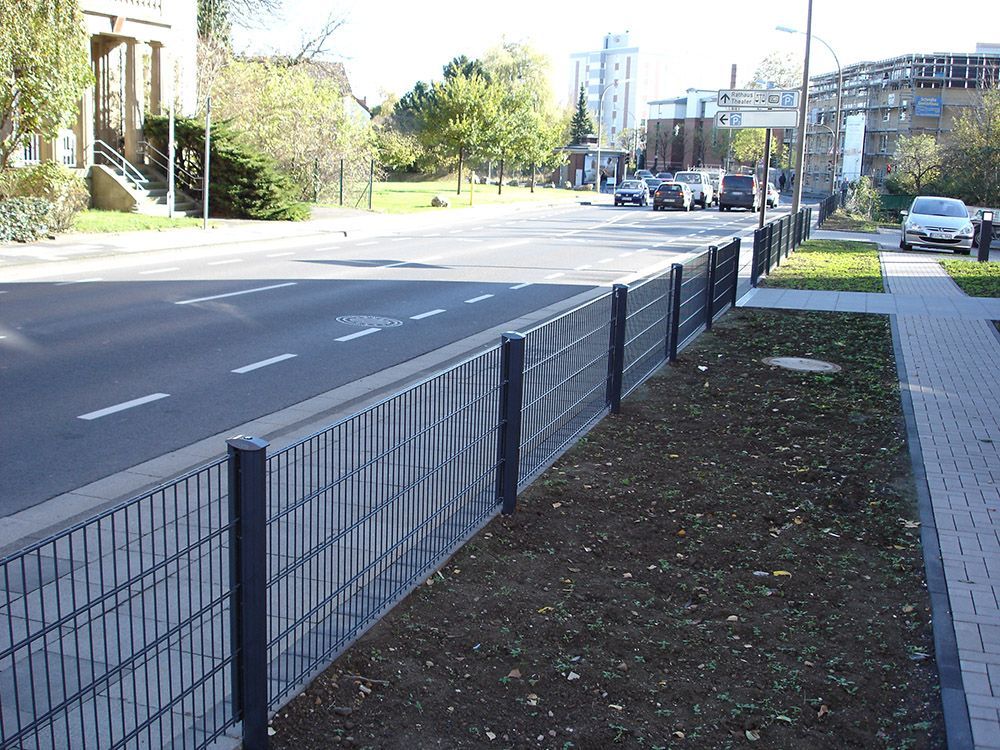 Ein schwarzer Zaun am Straßenrand