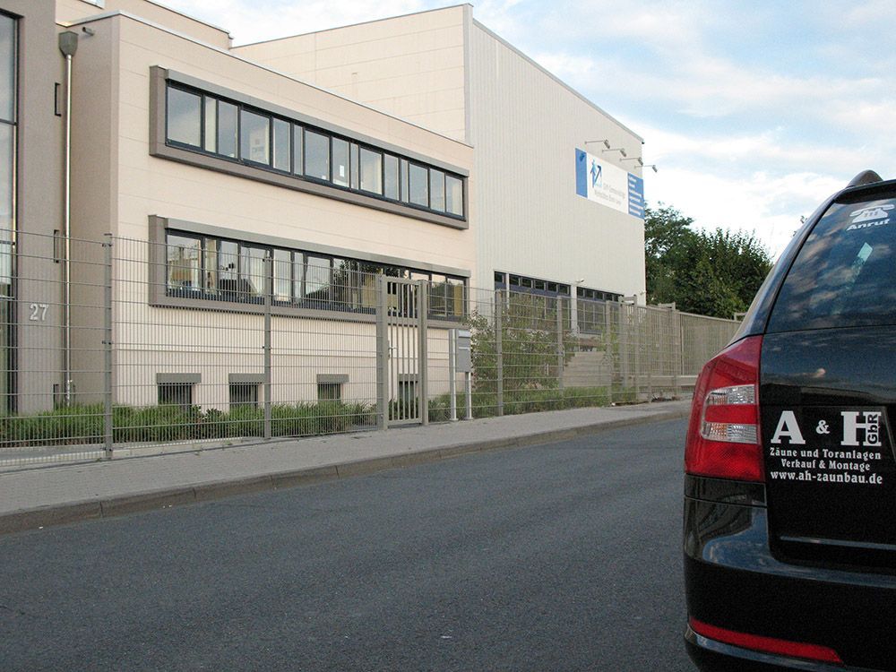 Ein schwarzes A&H-Auto steht vor einem Gebäude