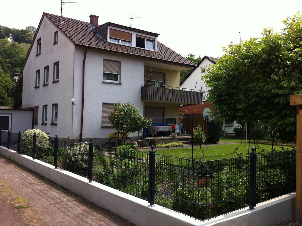 Ein weißes Haus mit einem Balkon und einem Zaun darum