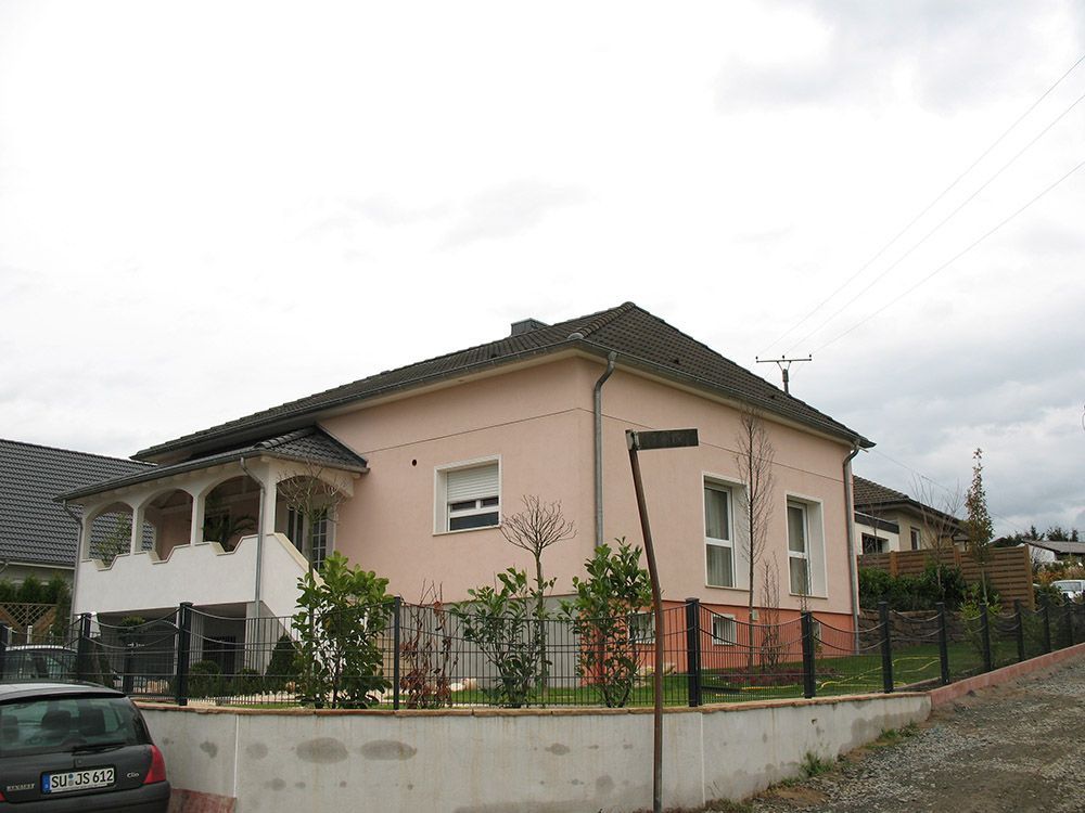 Ein rosa Haus mit einem davor geparkten Auto