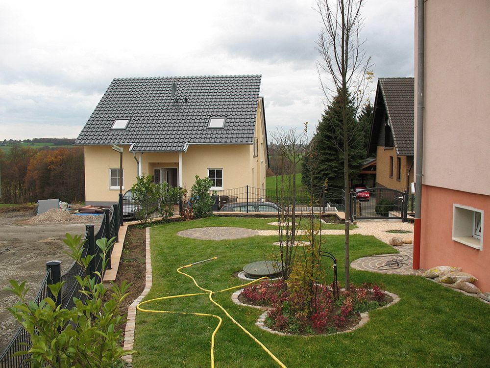Ein Schlauch liegt im Gras vor einem Haus