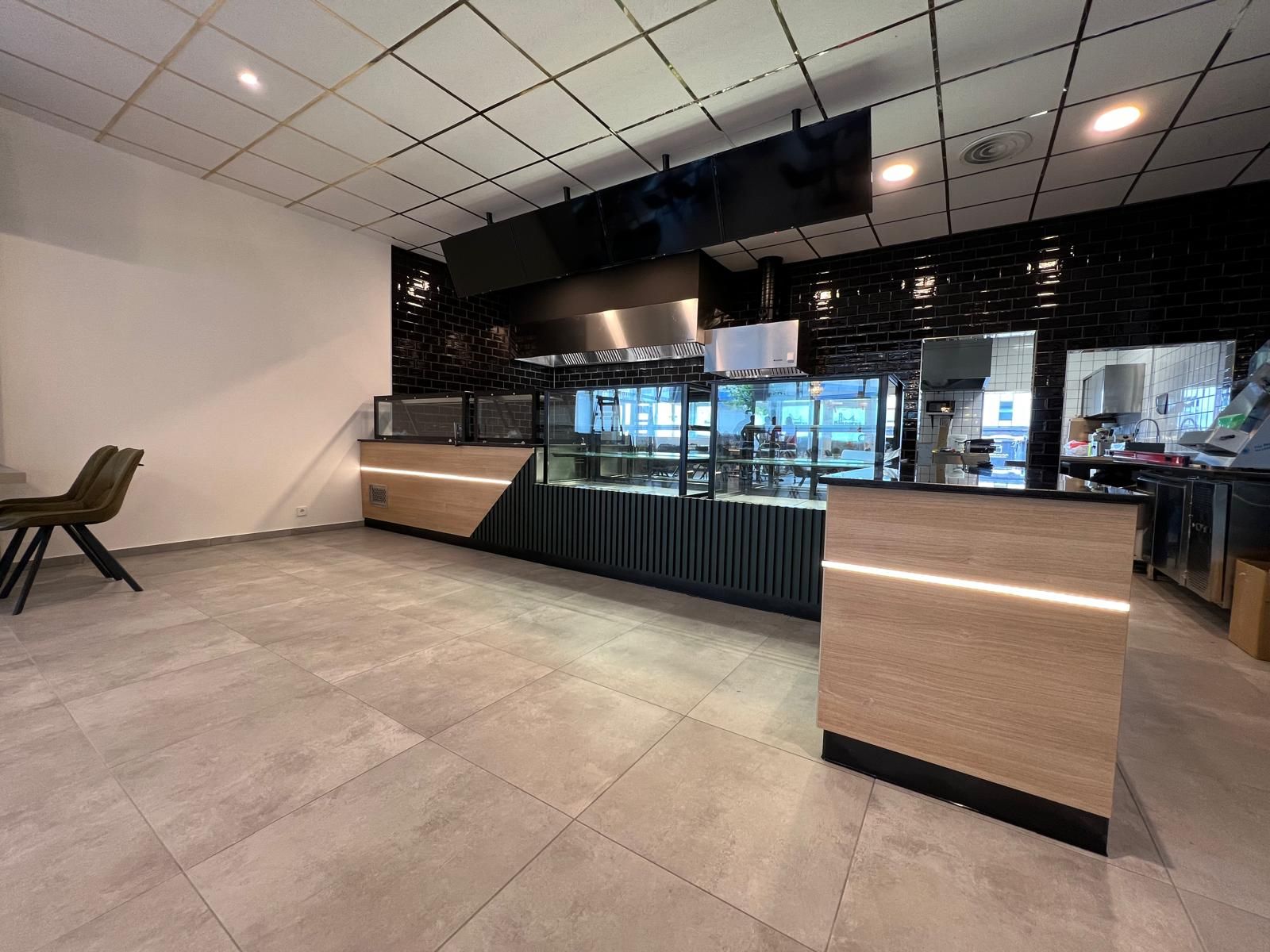 Leeres, modernes Restaurant-Interieur mit Theke, Vitrinen und Sitzgelegenheiten.