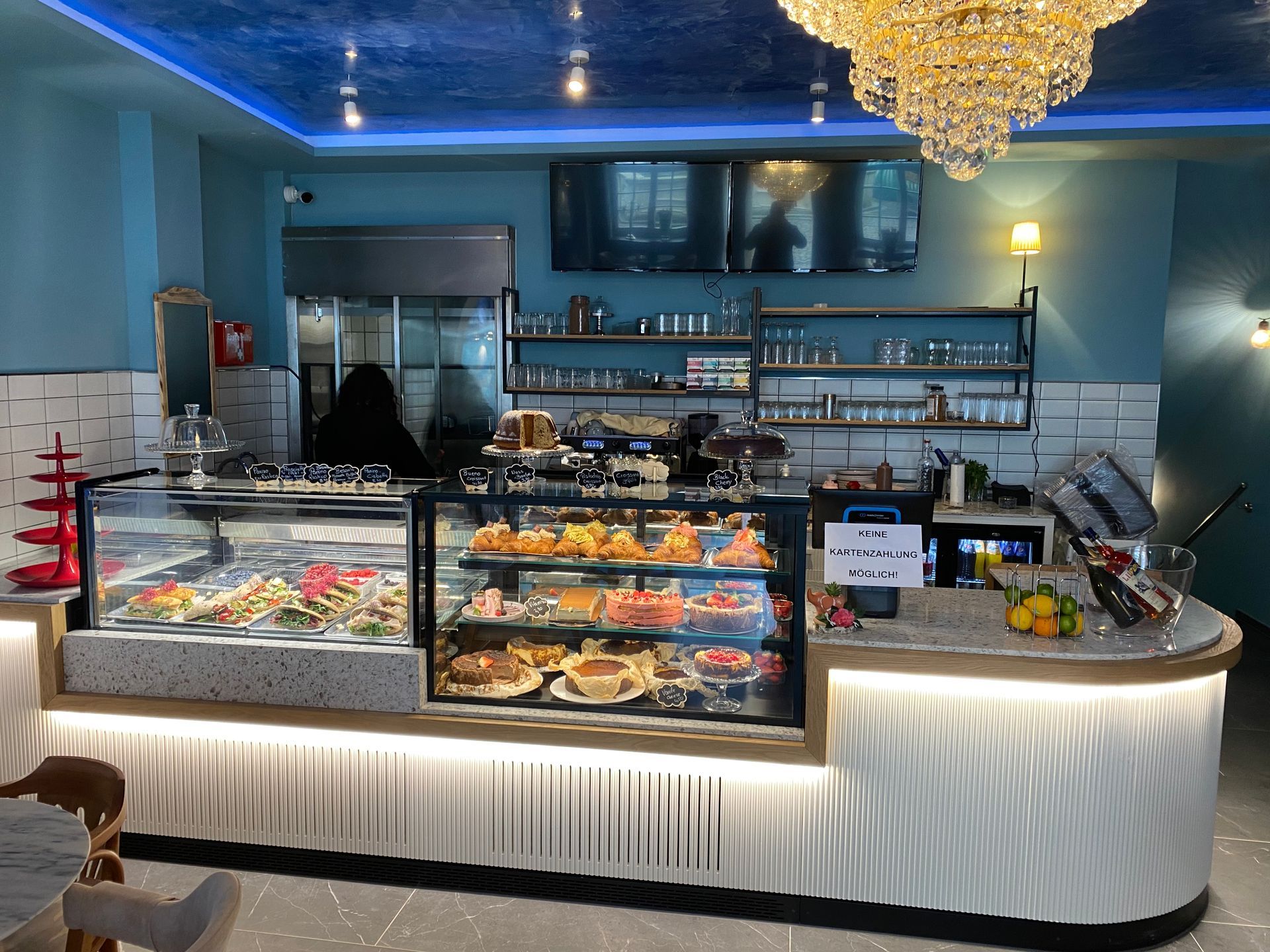 Innenansicht eines Restaurants mit einer Auslage von Gebäck und einer Theke.