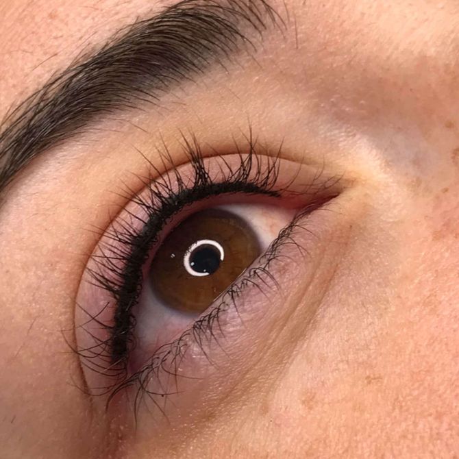 Un primer plano del ojo de una mujer con pestañas largas y delineador de ojos.