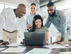 A group of people are looking at a laptop computer.