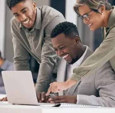 A group of people are looking at a laptop computer.