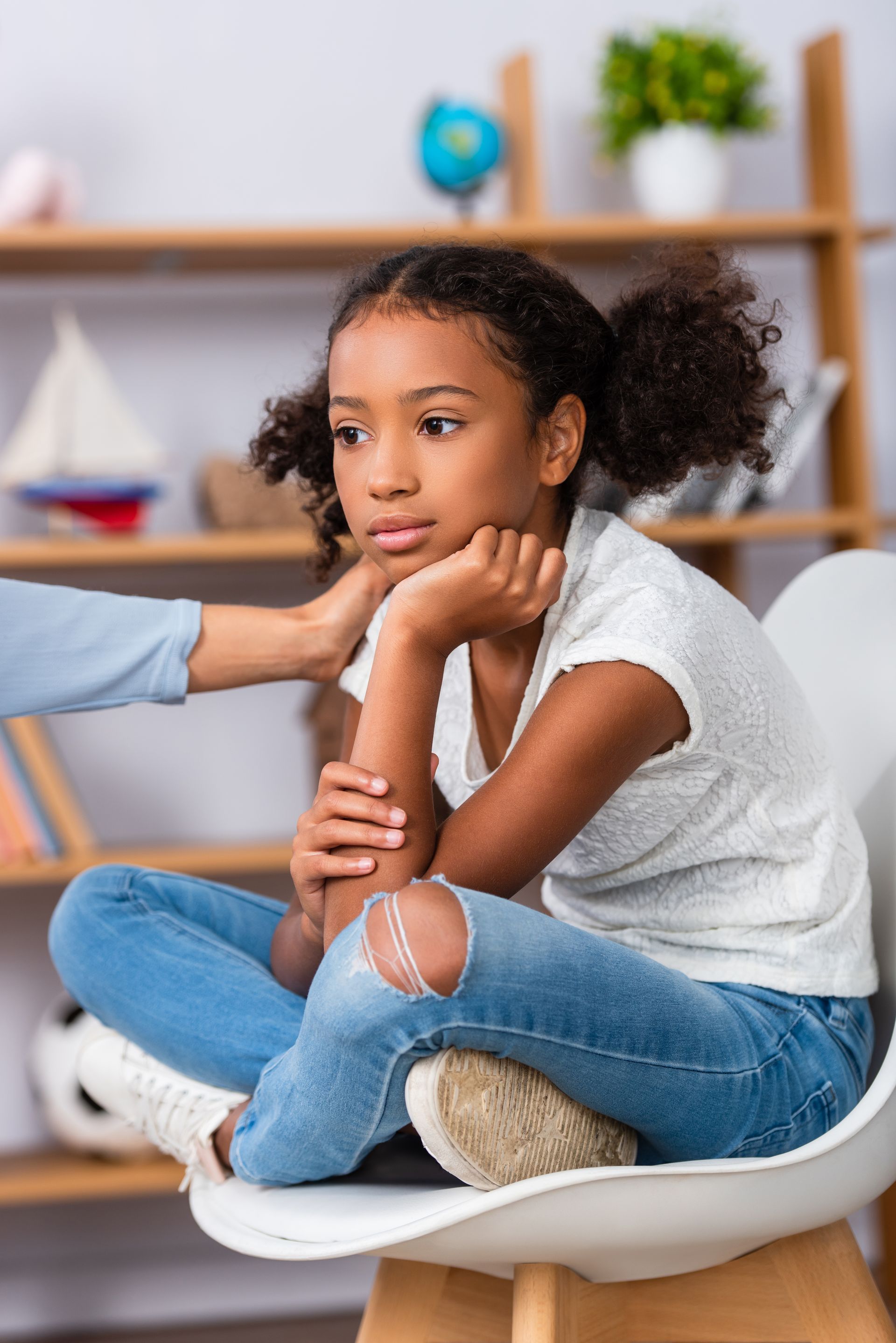 Adulte posant sa main sur l'épaule d'une enfant