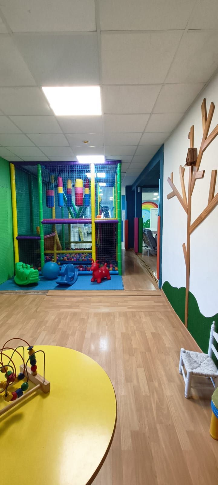 Una habitación con una mesa, sillas y juguetes.