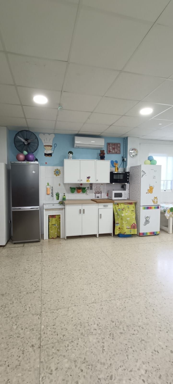 Una cocina con frigorífico, fregadero y microondas.