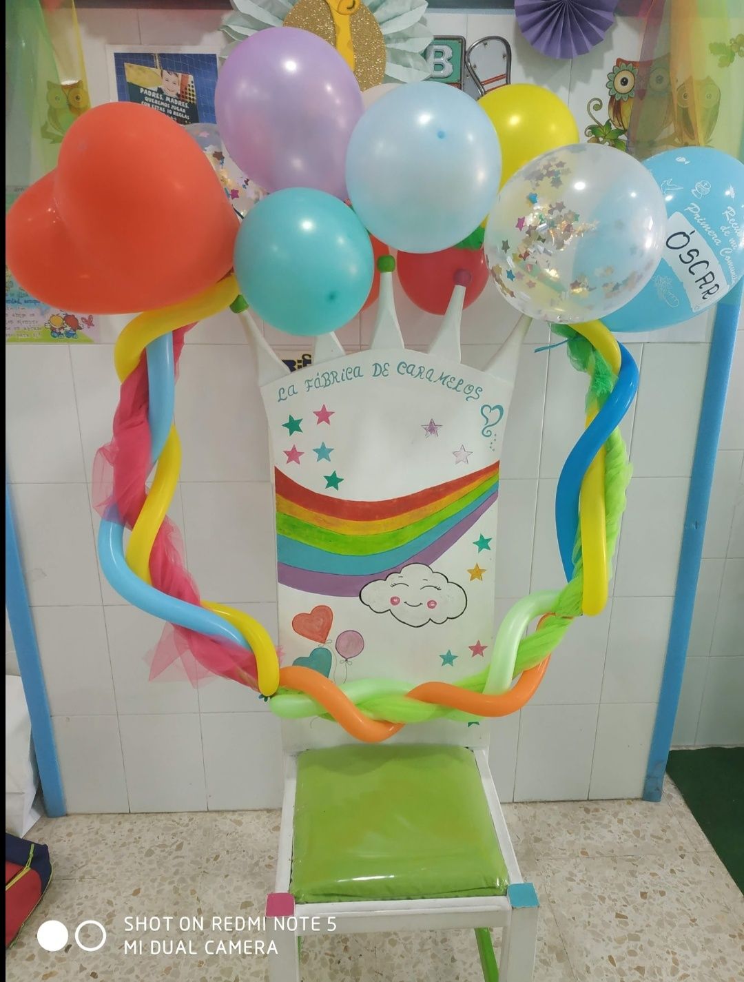 Una silla con globos y una corona encima.