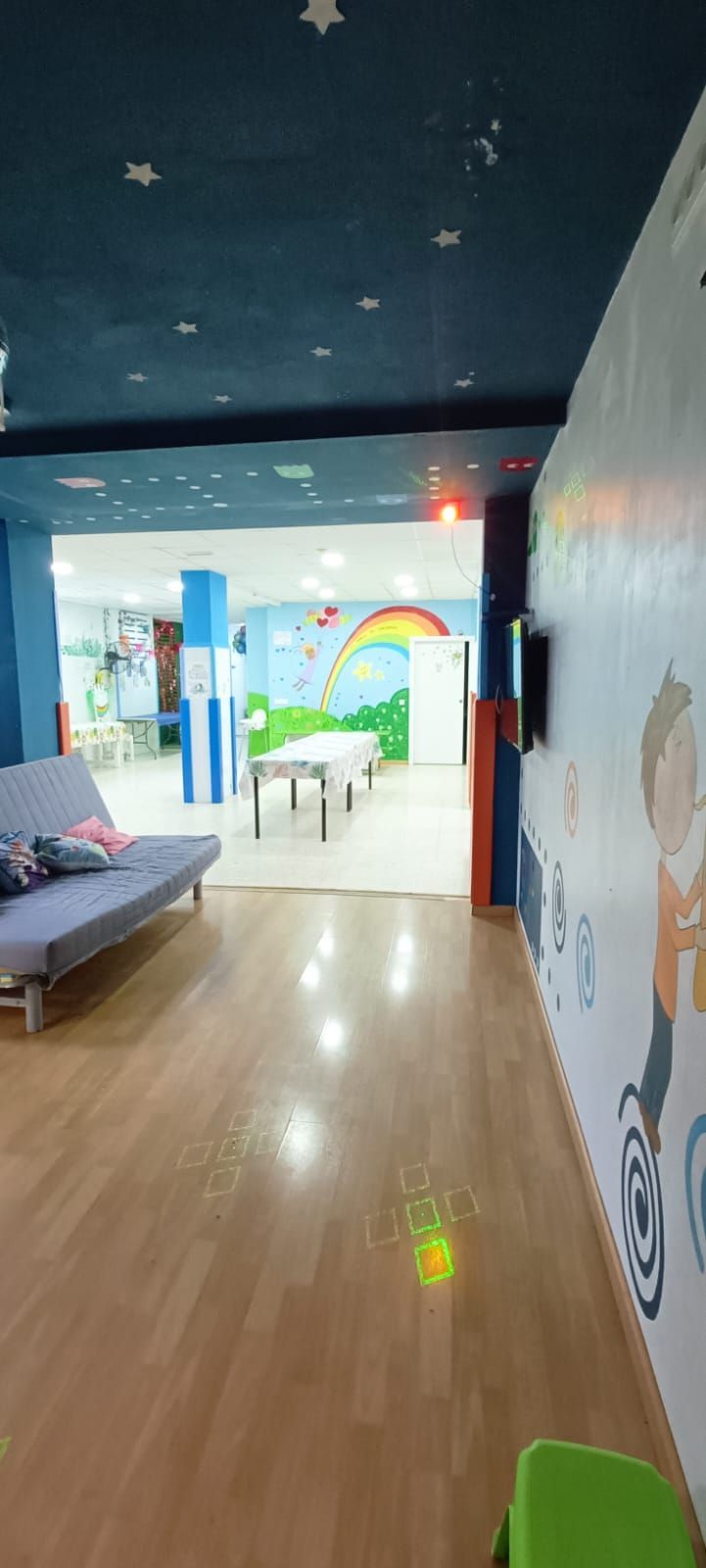 Una habitación con un sofá, una mesa y sillas.