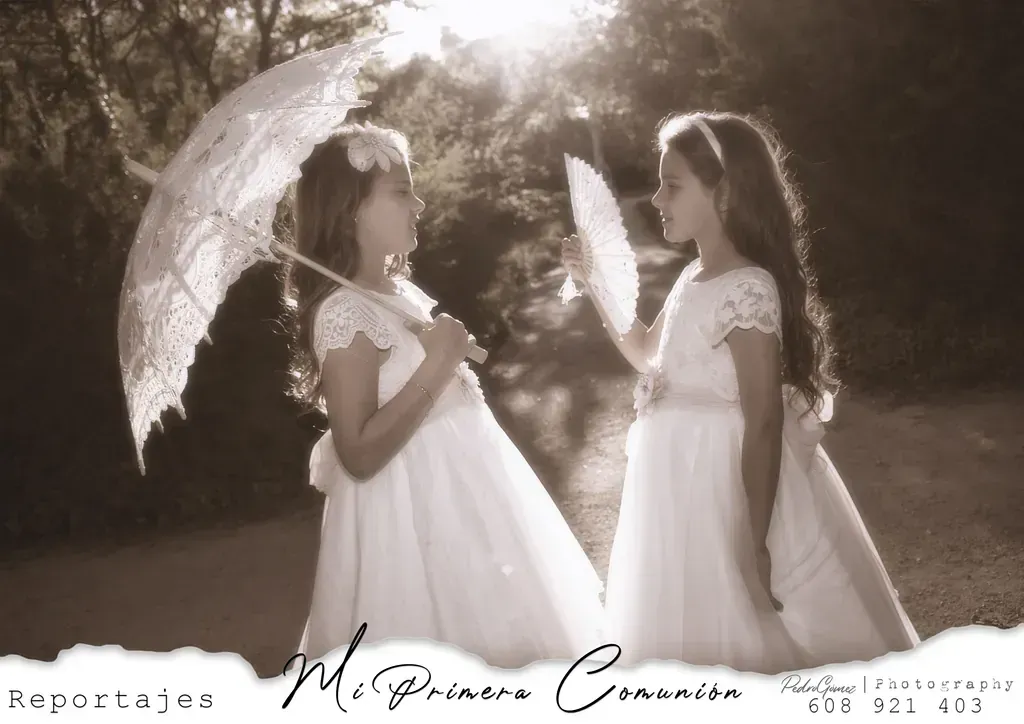 Dos niñas con vestidos blancos sosteniendo paraguas y abanicos