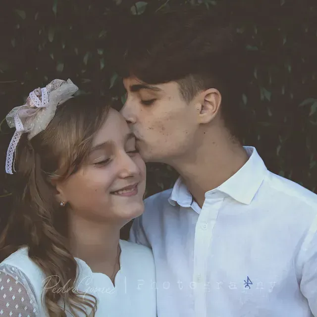 Un hombre está besando a una chica en la mejilla.