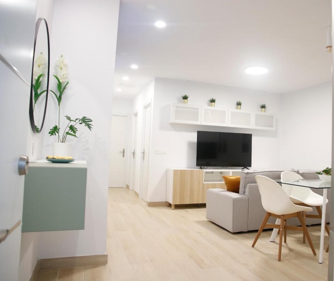 Una sala de estar con un sofá y sillas y un televisor de pantalla plana.