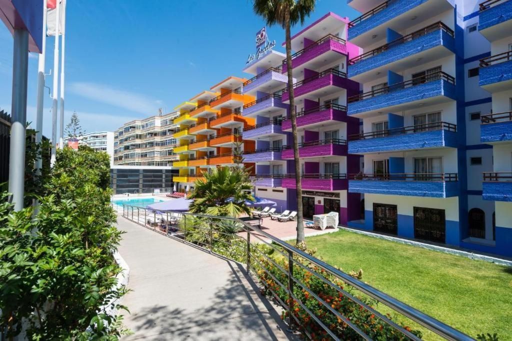 Una fila de coloridos edificios de apartamentos están alineados uno al lado del otro en un día soleado.