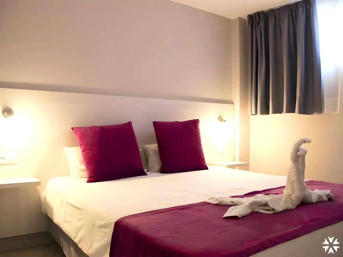 Una habitación de hotel con una cama y una ventana.