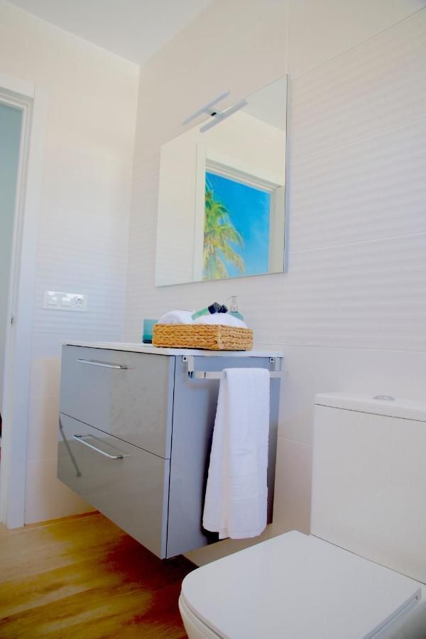 Un baño con inodoro, lavabo y espejo.