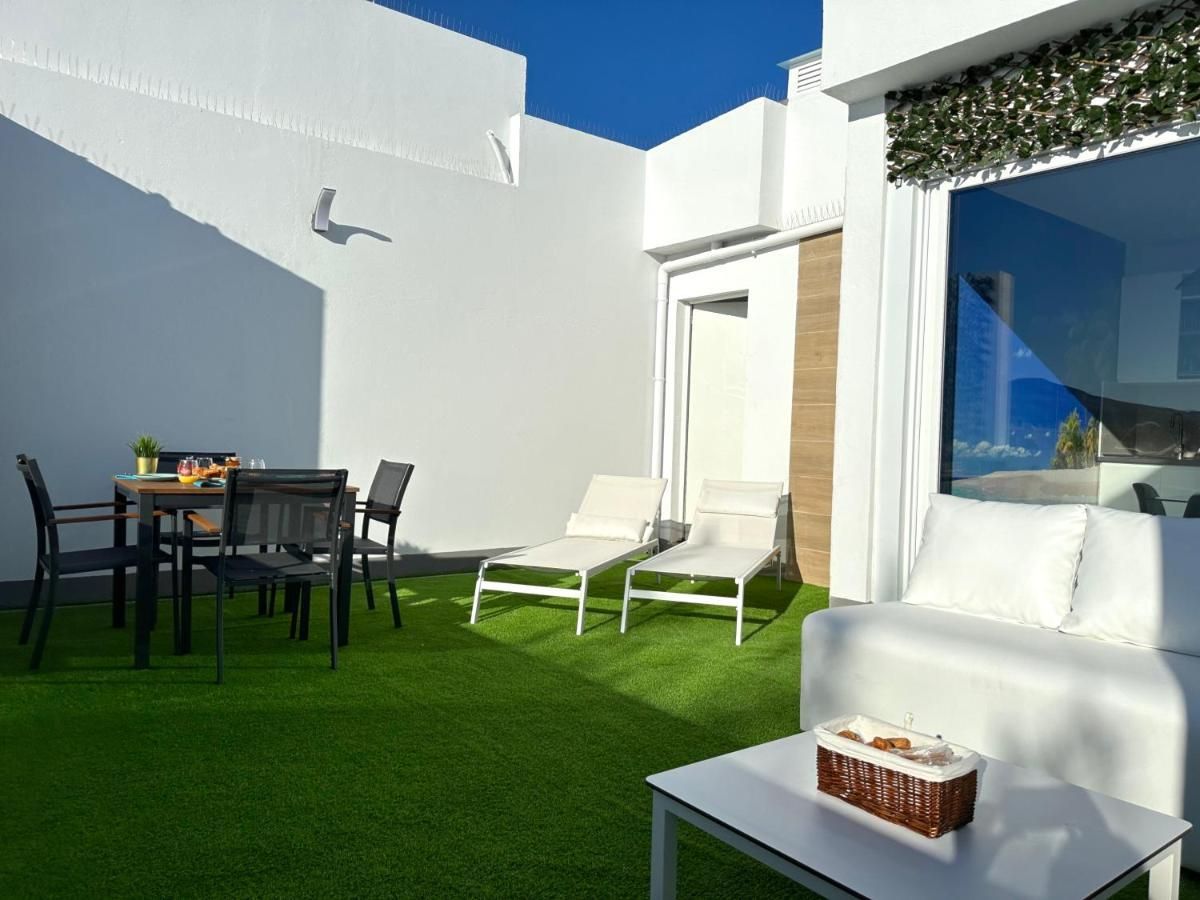 Hay una mesa y sillas en el patio trasero de una casa.