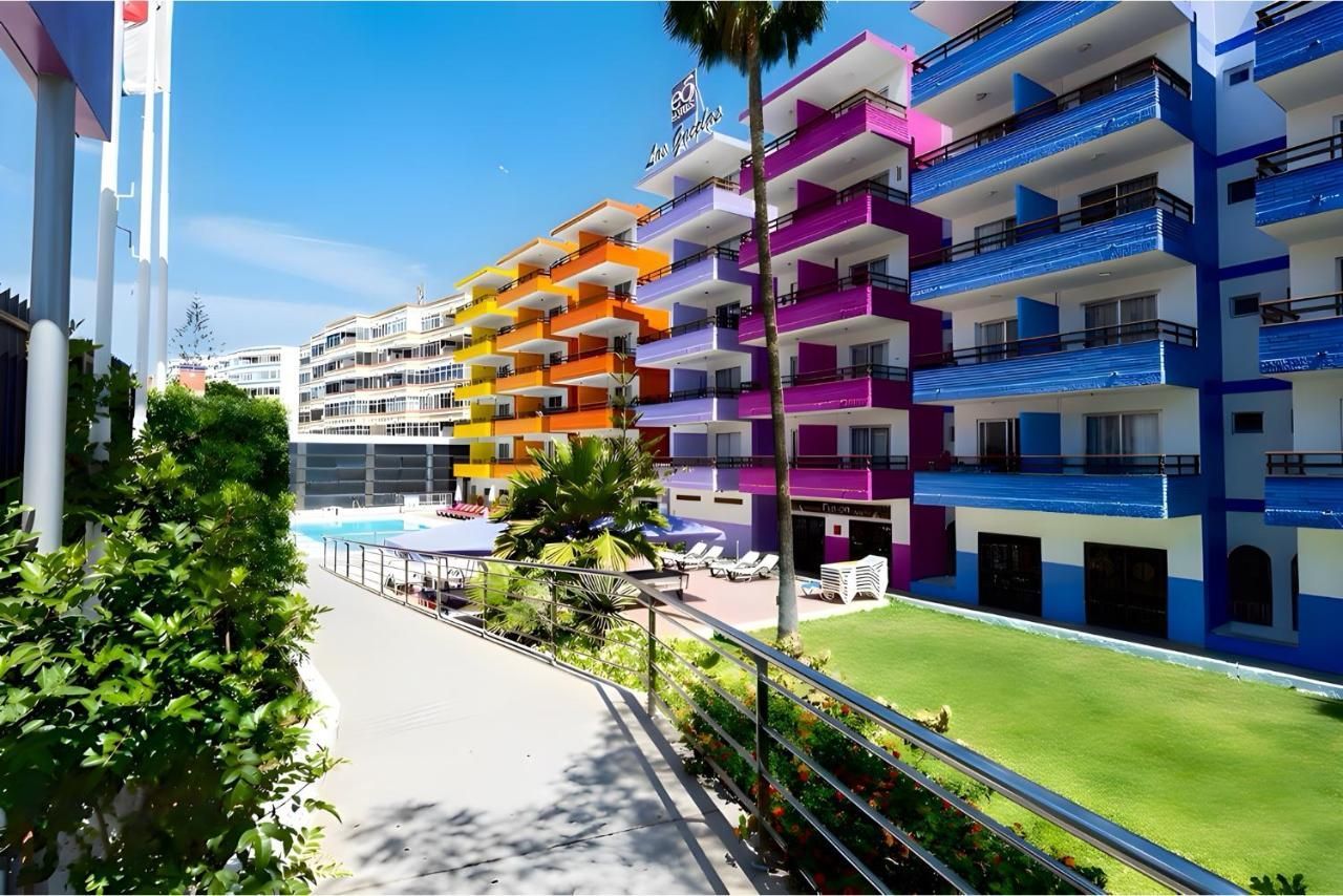 Una hilera de coloridos edificios de apartamentos con una piscina en el medio.