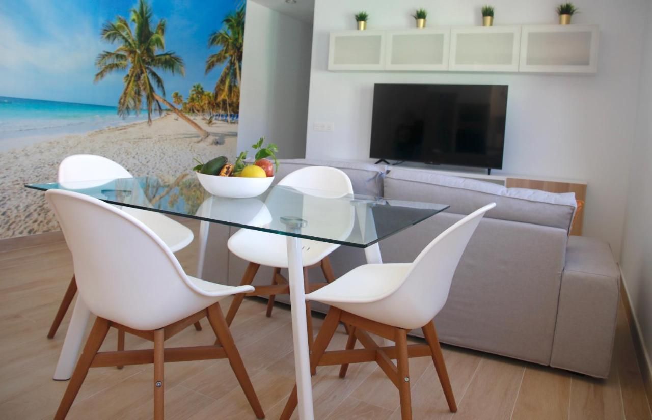 Una sala de estar con una mesa y sillas y un televisor.