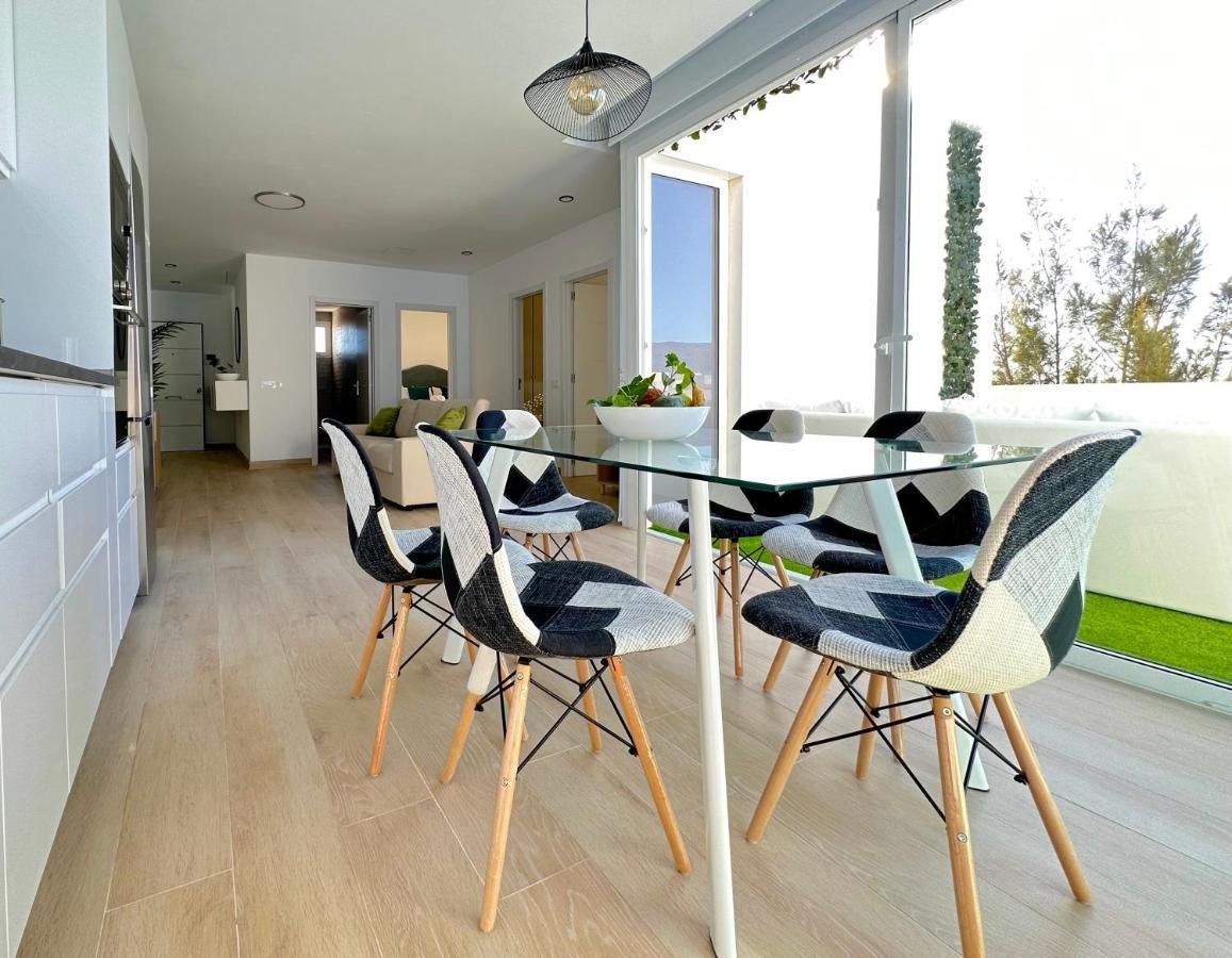 Un comedor con una mesa de cristal y sillas en una casa.