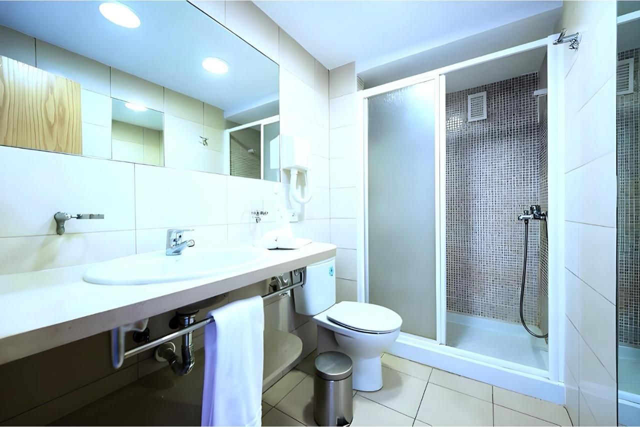 Un baño con inodoro, lavabo y ducha.