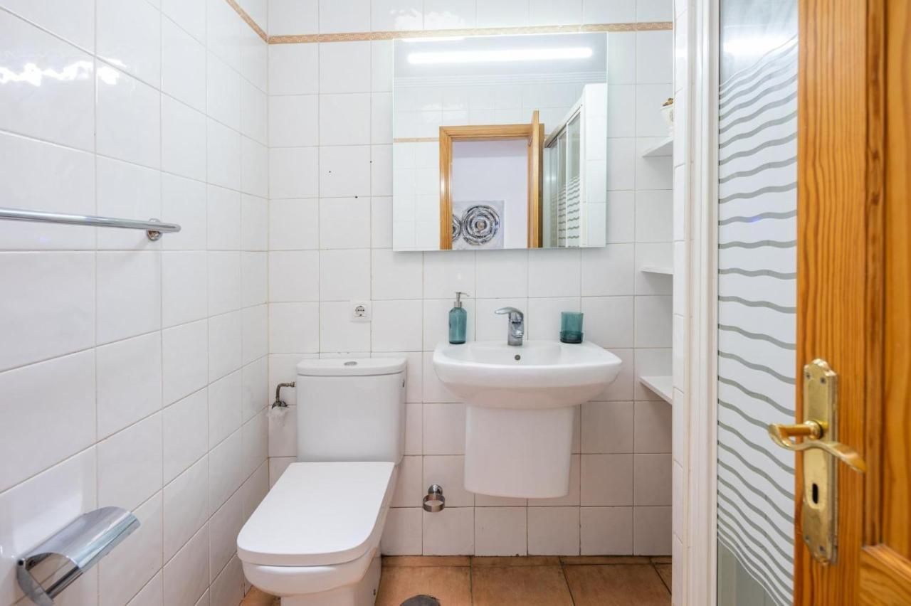 Un baño con inodoro, lavabo y espejo.