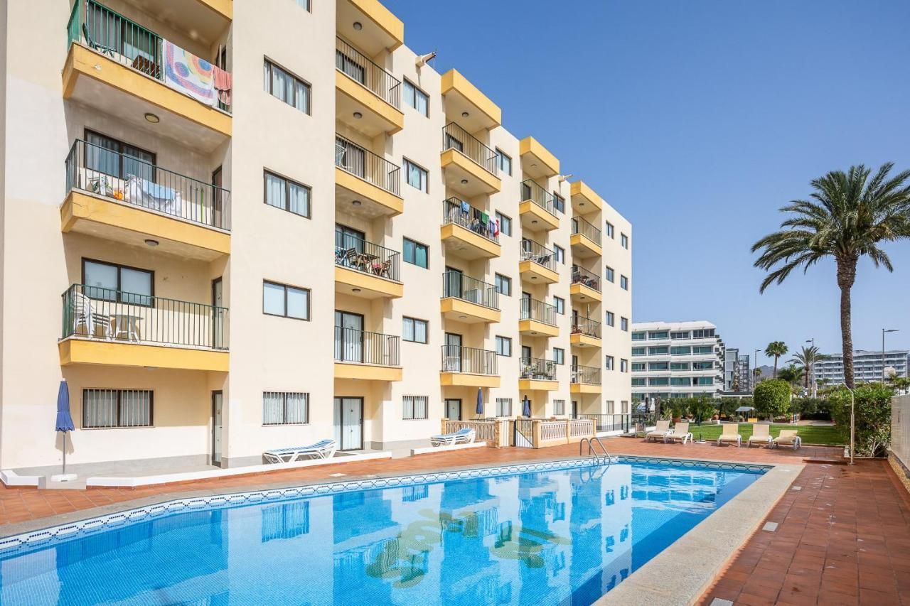 Un gran edificio con una piscina en frente.