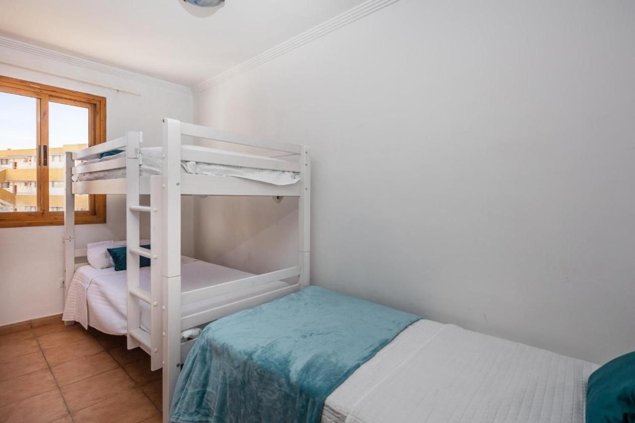 Un dormitorio con dos literas y una ventana.