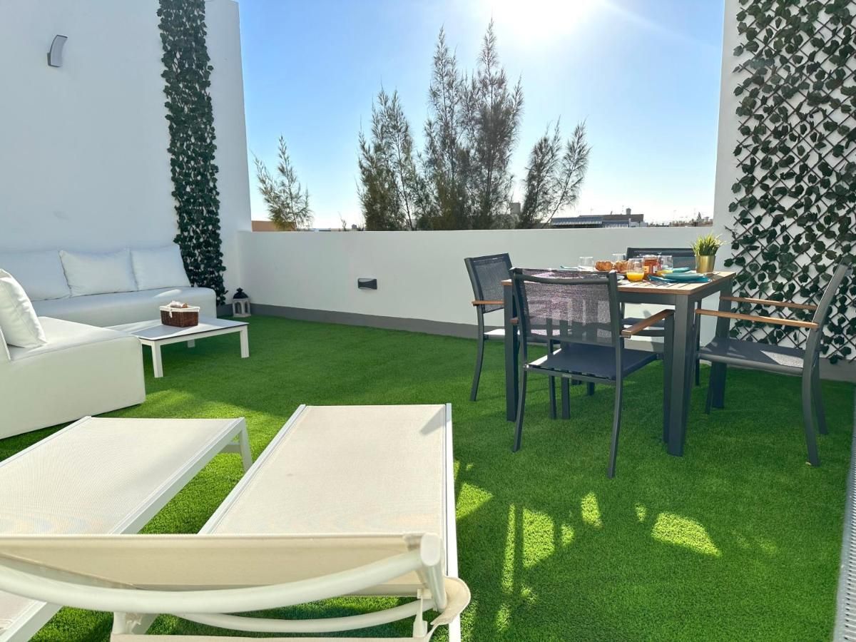 Un patio con una mesa y sillas y un sofá.