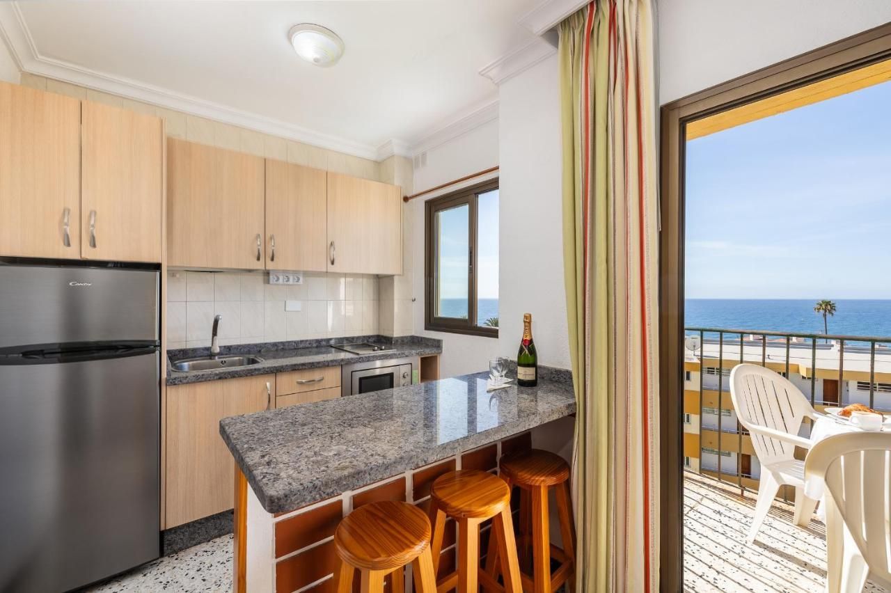 Una cocina con una botella de champán en la encimera y vistas al océano.