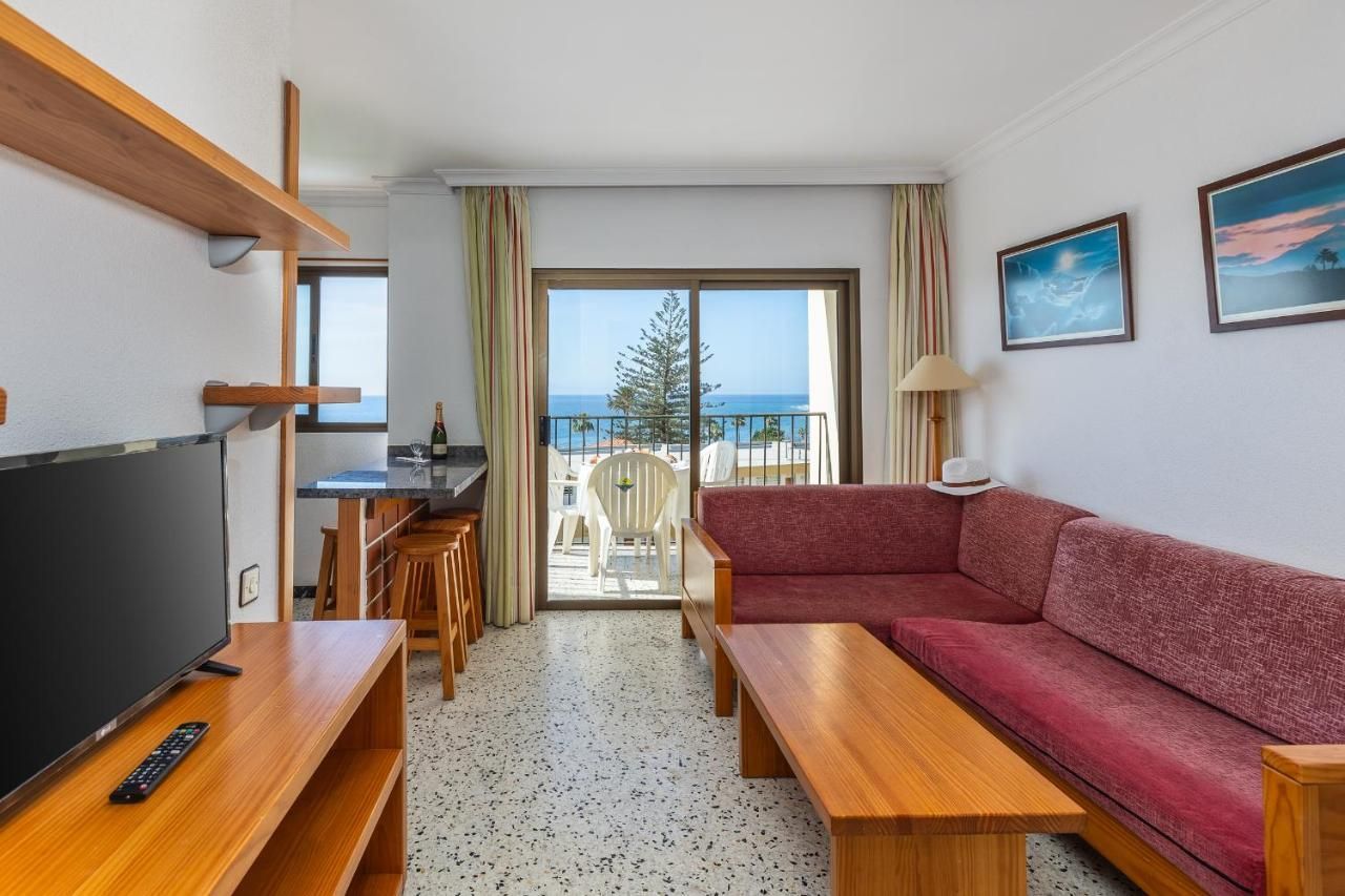 Una sala de estar con un sofá y un televisor de pantalla plana.