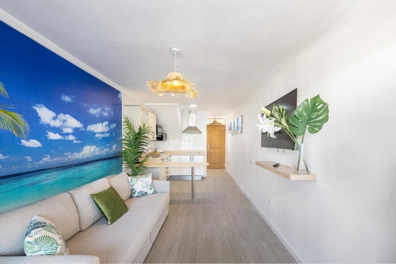 Una sala de estar con un sofá y un televisor en la pared.