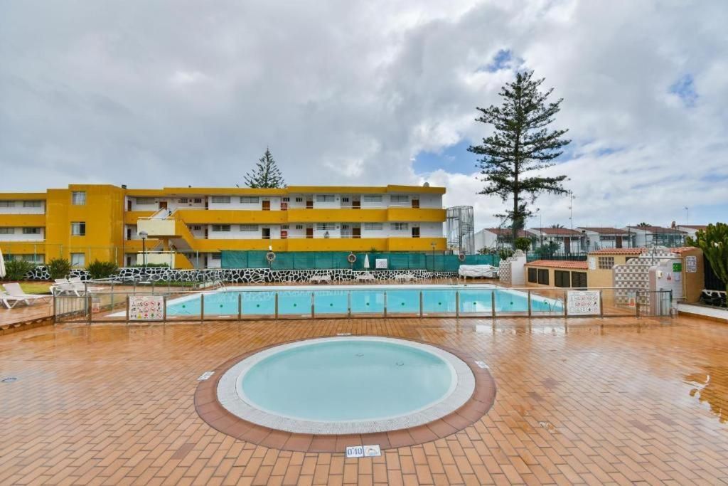 Una gran piscina con jacuzzi en el medio.