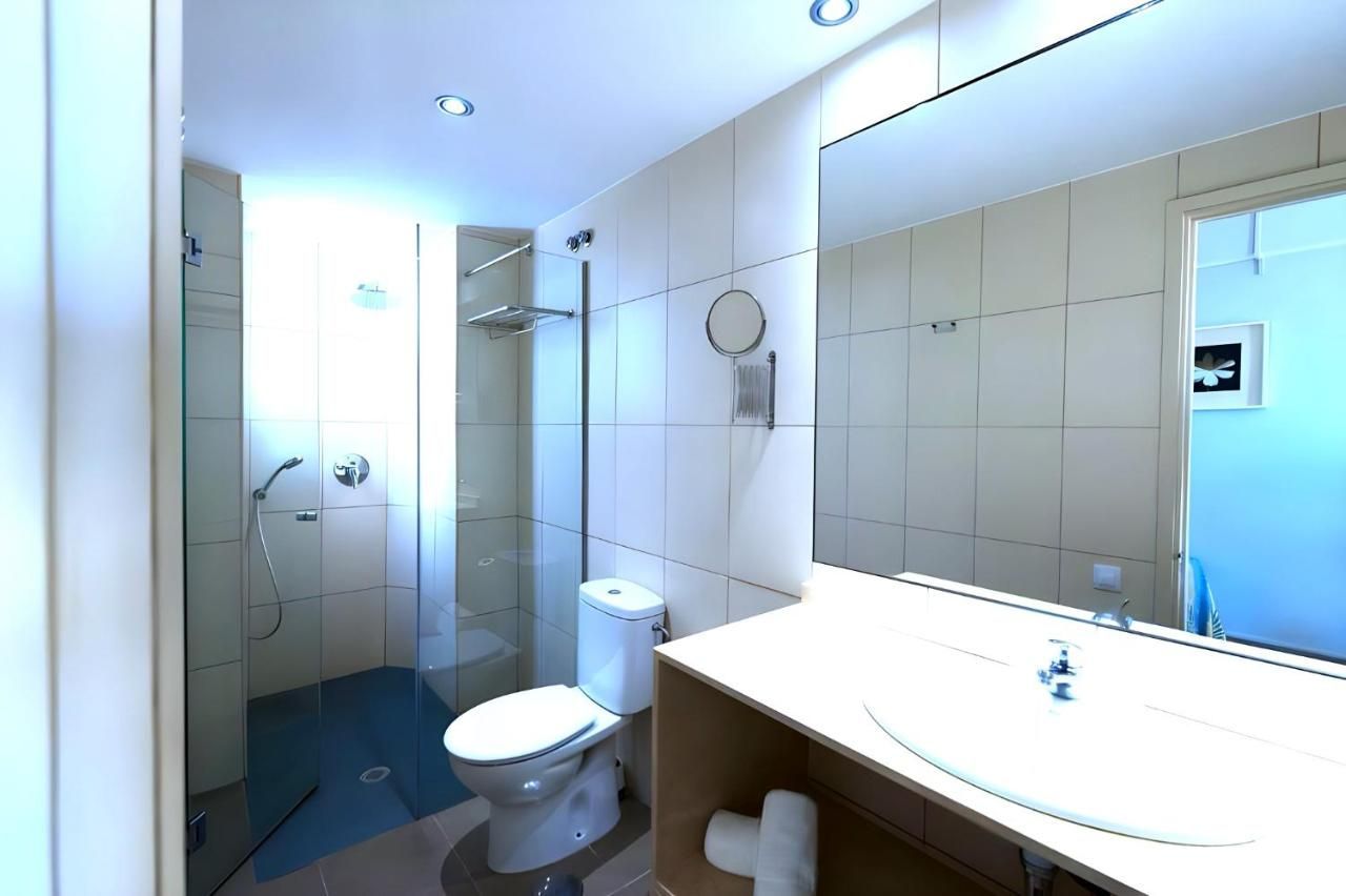 Un baño con inodoro, lavabo y espejo.