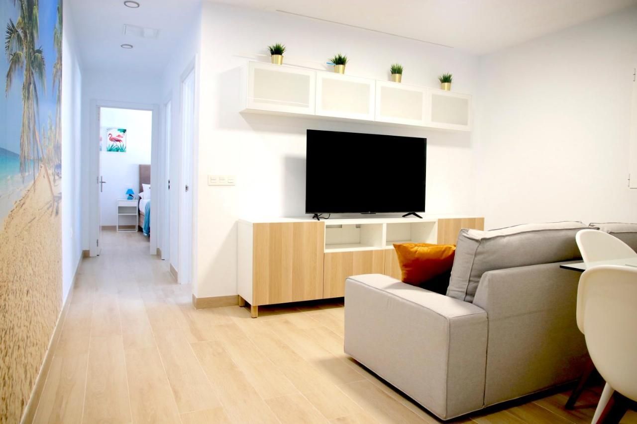 Una sala de estar con sofá, silla y televisión.