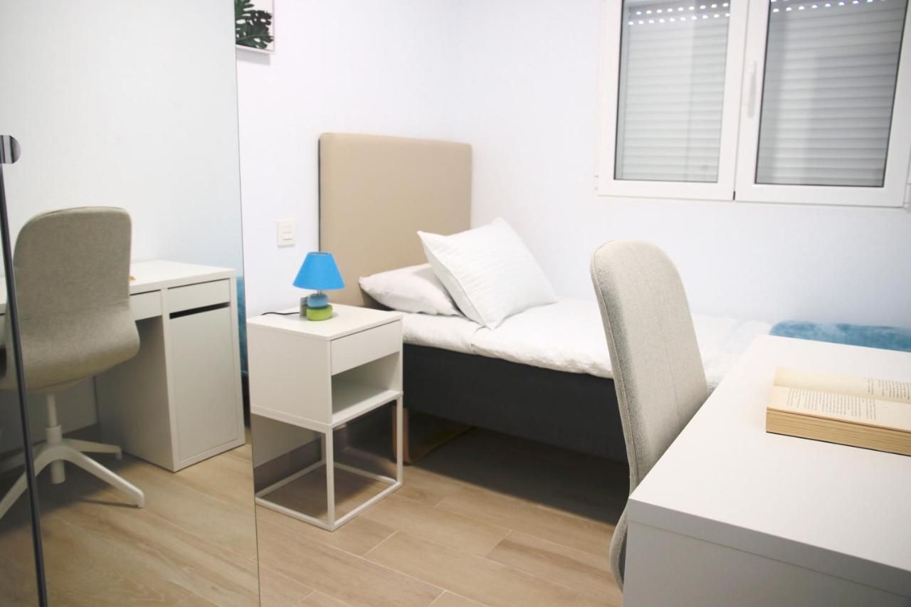 Un dormitorio con una cama individual, escritorio y silla.