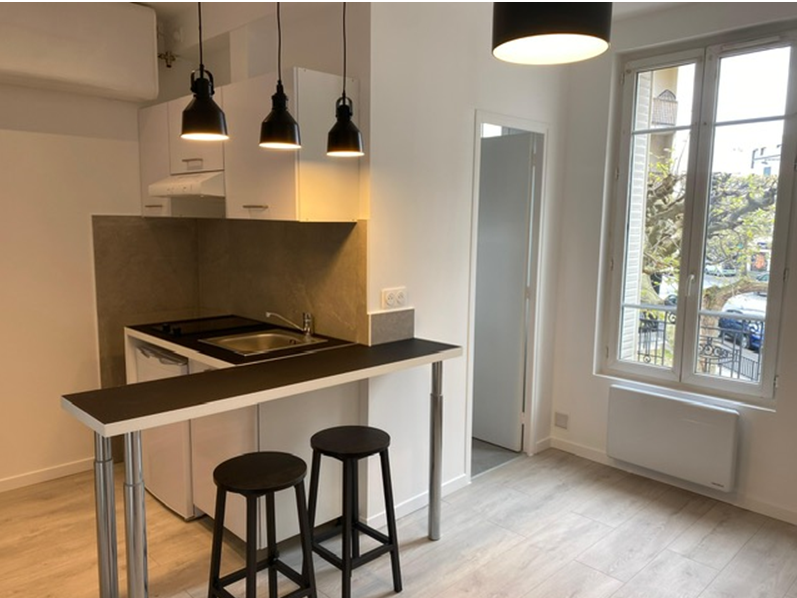 Kitchenette avec un bar ouvert sur un salon