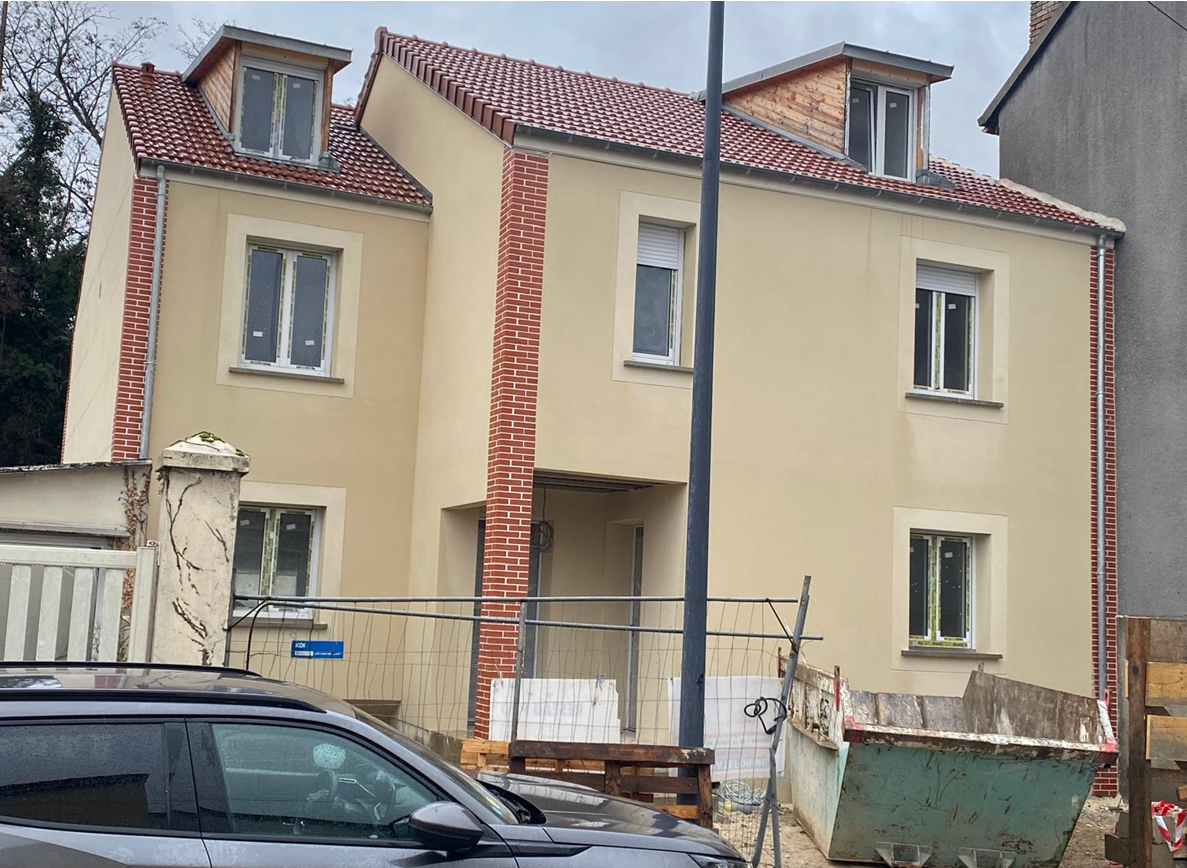 Maison avec crépi couleur sable et briquettes rouge sur la façade