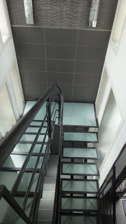 Vue verticale sur une cage d’escalier  en métal et verre