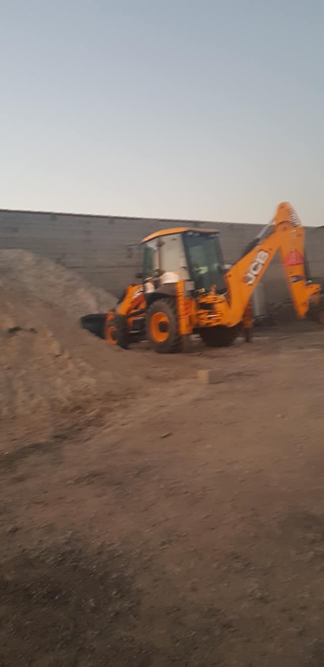 Una excavadora amarilla avanza por un camino de tierra.