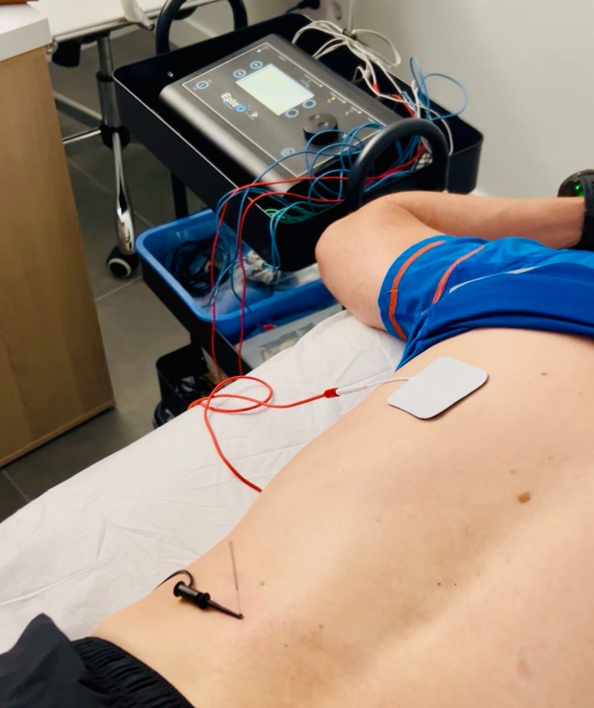 Médico realizando una ecografía a un paciente en la sala de examen.