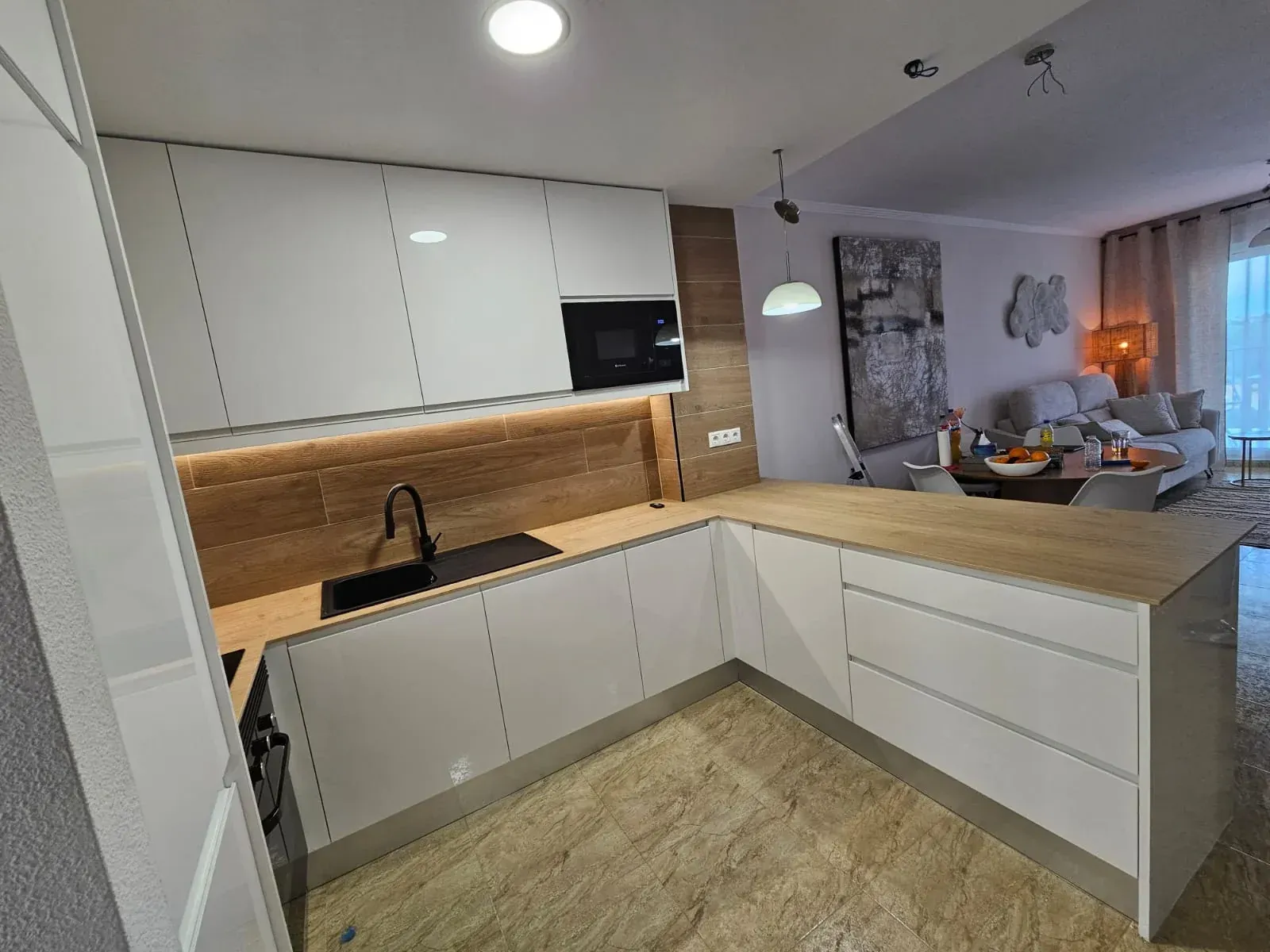 Persona con traje de protección rociando un sistema de pesticida montado en un vehículo sobre arbustos