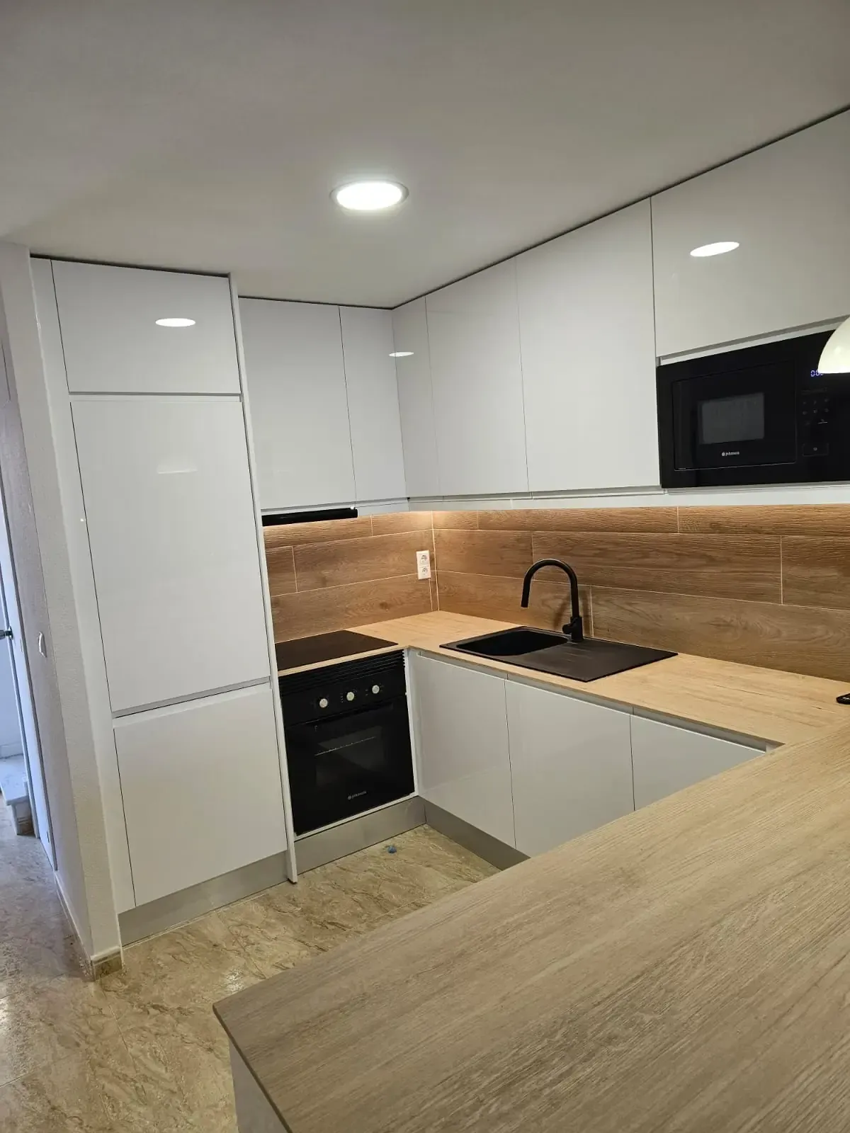 Persona con traje de protección rociando un sistema de pesticida montado en un vehículo sobre arbustos