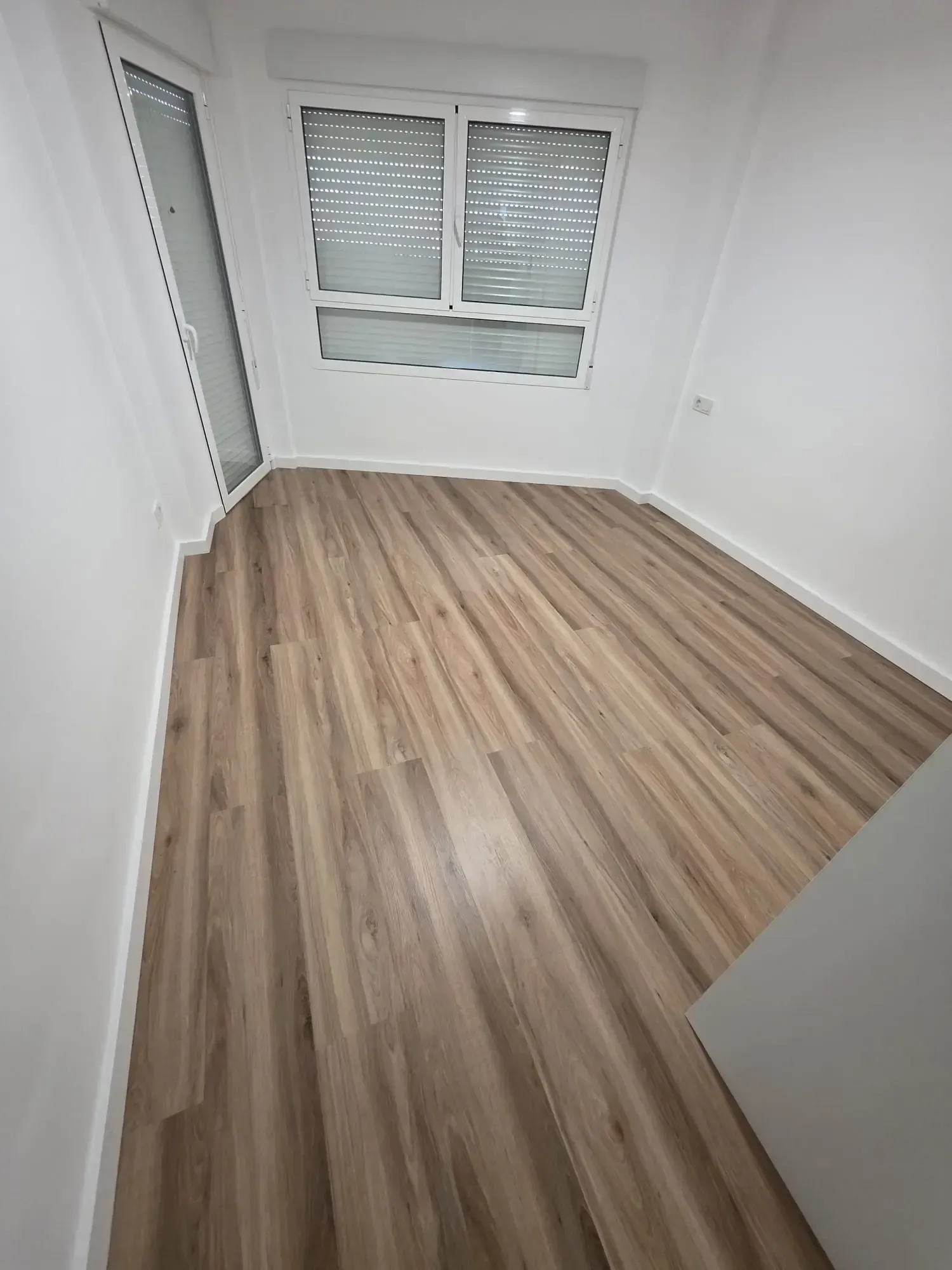 Persona con traje de protección rociando un sistema de pesticida montado en un vehículo sobre arbustos